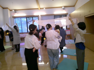 布で作ったトンネルをくぐって遊ぶ親子の様子の画像