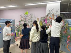 笹に七夕の飾りつけをする学生