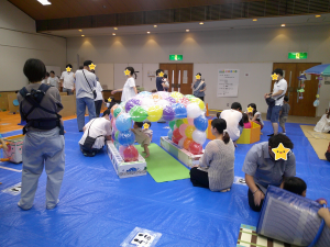 風船で作ったトンネルで遊ぶ子どもの画像