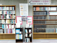 太宰府市民図書館の関連書籍特集コーナーの写真。上に横断幕、その下に締結経緯のパネル。ほか、これまでの交流について掲載